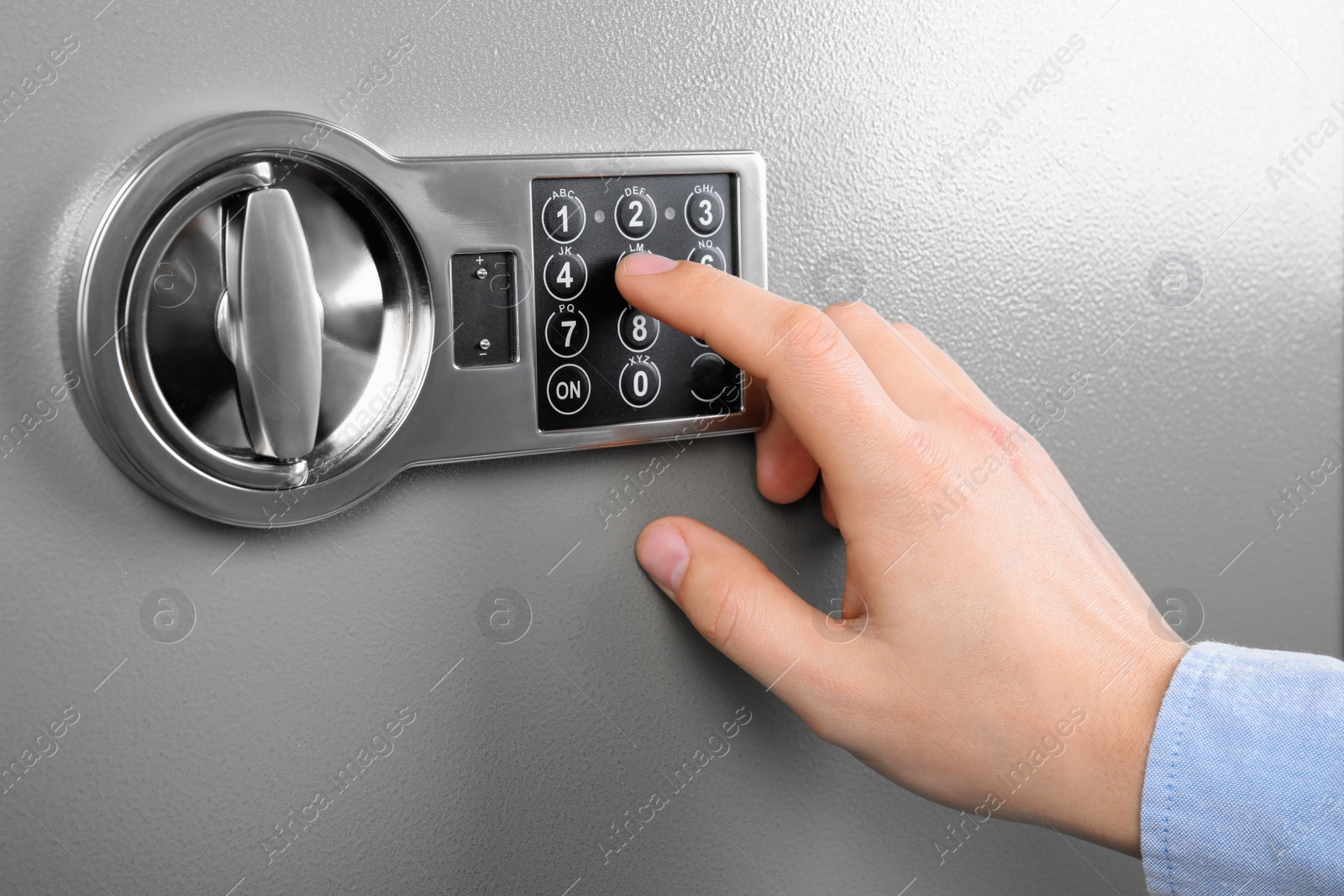 Photo of Man opening steel safe with electronic combination lock, closeup