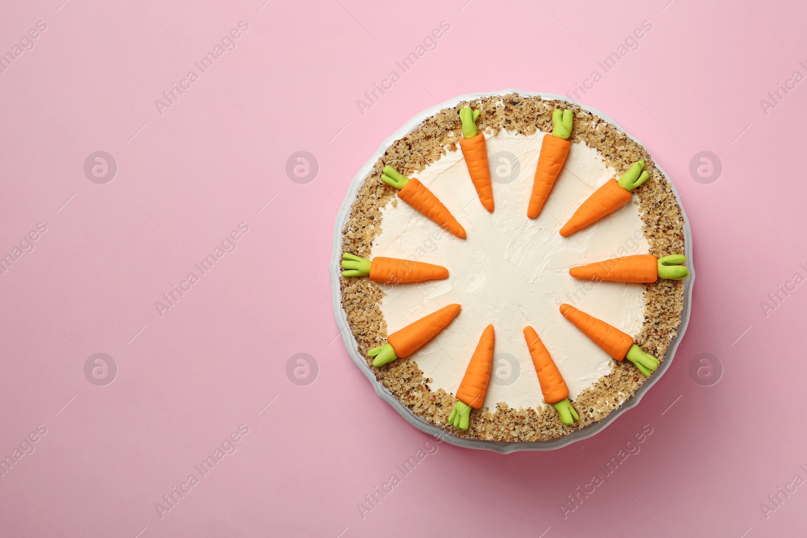 Photo of Dish with tasty carrot cake on pink background, top view. Space for text