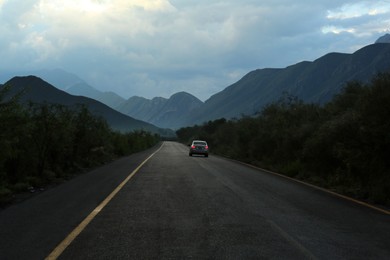 Beautiful view of car on asphalt highway in mountains. Road trip