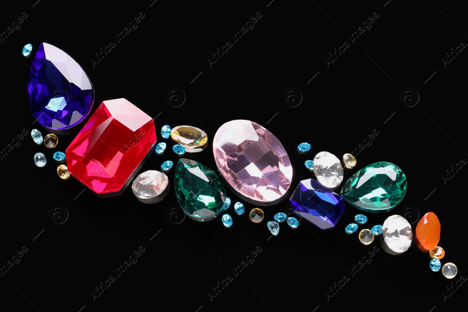 Photo of Different beautiful gemstones for jewelry on black background, flat lay