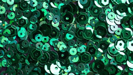 Photo of Many beautiful green sequins as background, closeup