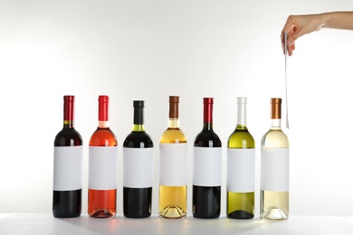 Photo of Bottles with different wine on white background