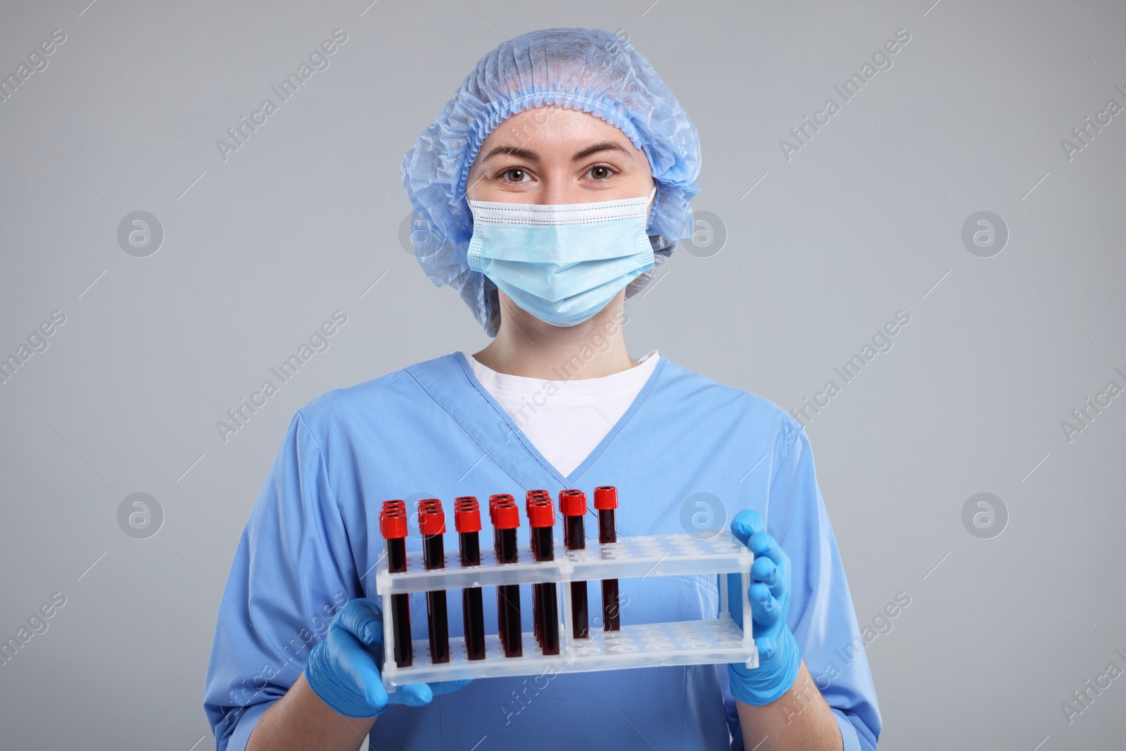 Photo of Laboratory testing. Doctor with blood samples in tubes on light grey background