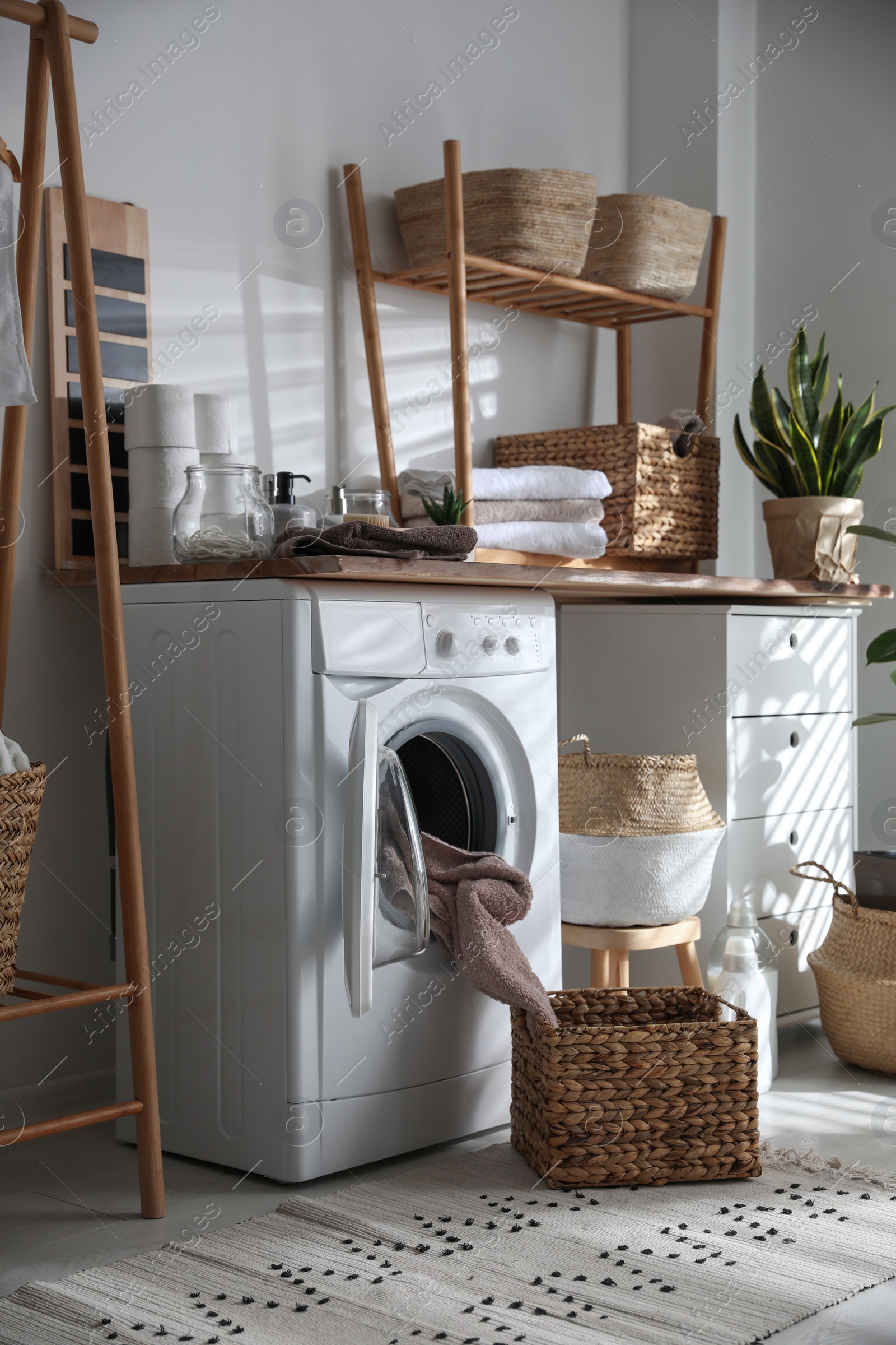 Photo of Stylish bathroom interior with modern washing machine