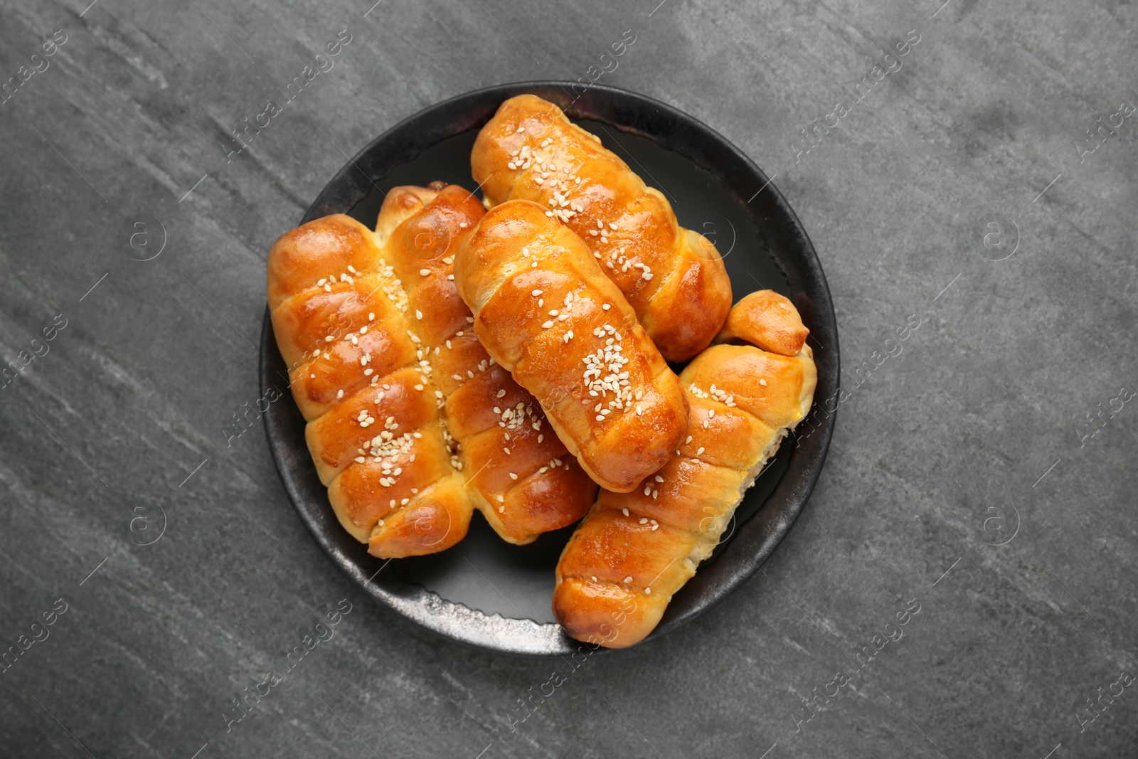 Photo of Delicious sausage rolls on grey table, top view