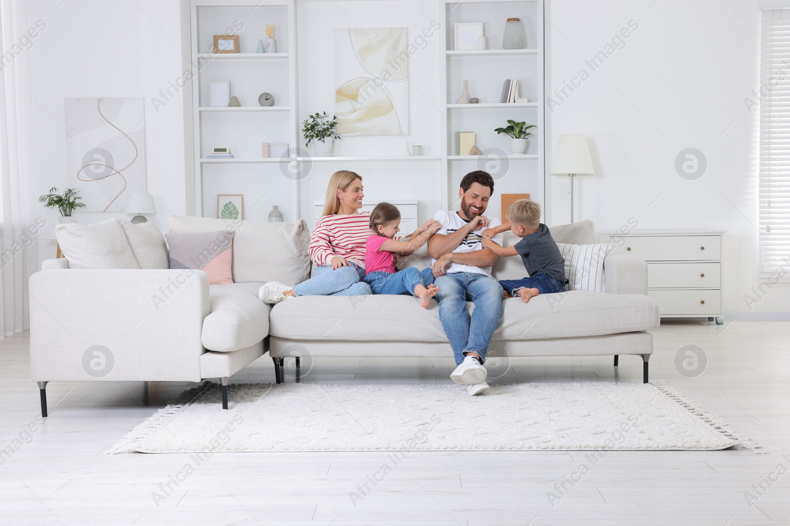 Photo of Happy family having fun together on sofa at home