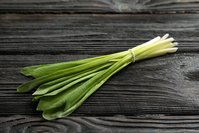 Photo of Bunch of wild garlic or ramson on wooden table, closeup