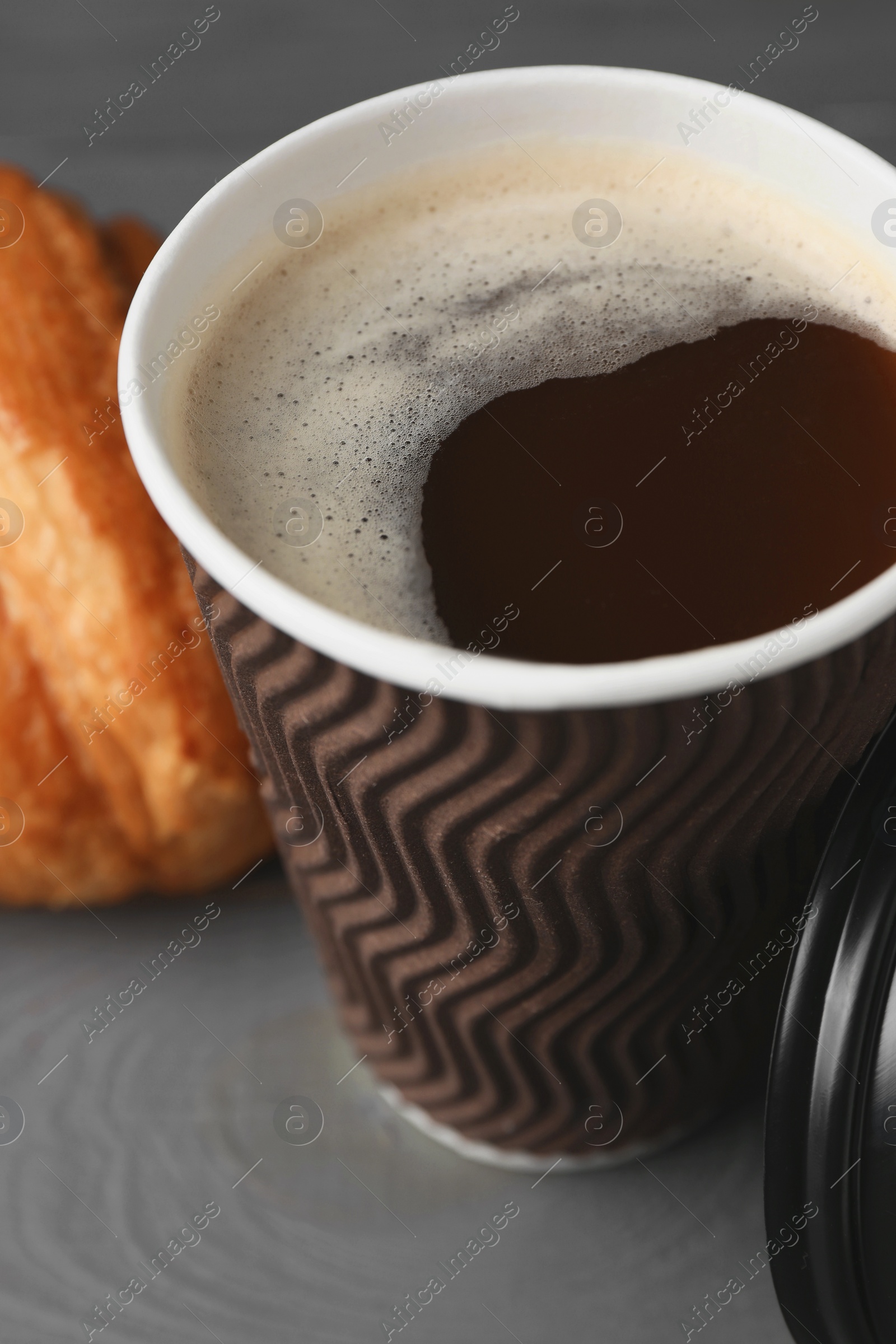 Photo of Coffee to go. Paper cup with tasty drink on grey table, closeup
