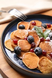 Photo of Cereal pancakes with berries on wooden board
