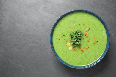 Photo of Tasty kale soup on grey table, top view. Space for text