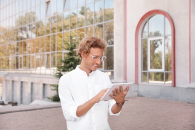 Photo of Male real estate agent with tablet outdoors