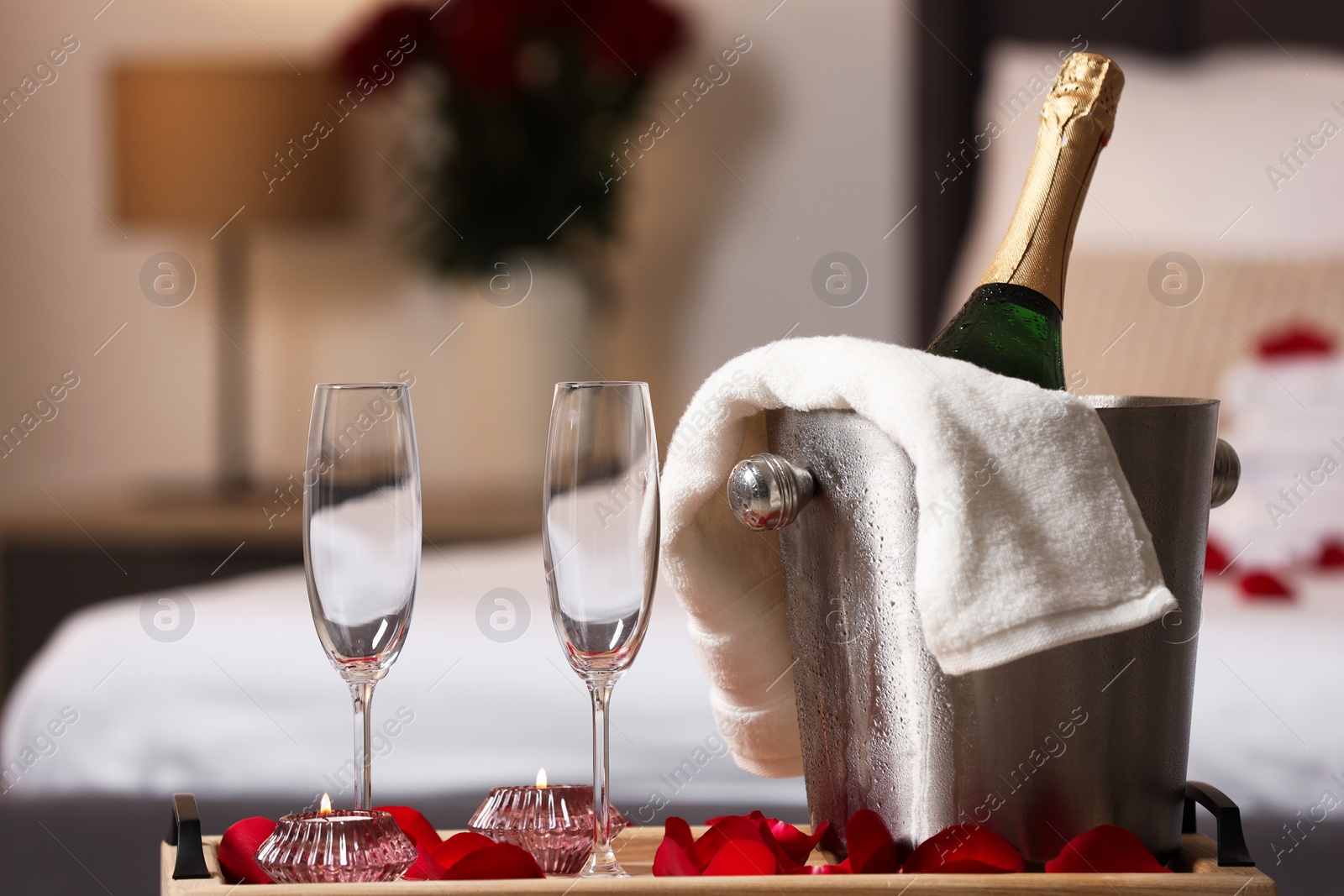 Photo of Honeymoon. Sparkling wine and glasses on wooden table in room