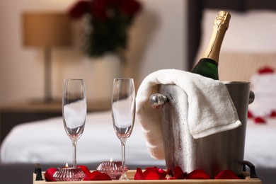 Honeymoon. Sparkling wine and glasses on wooden table in room