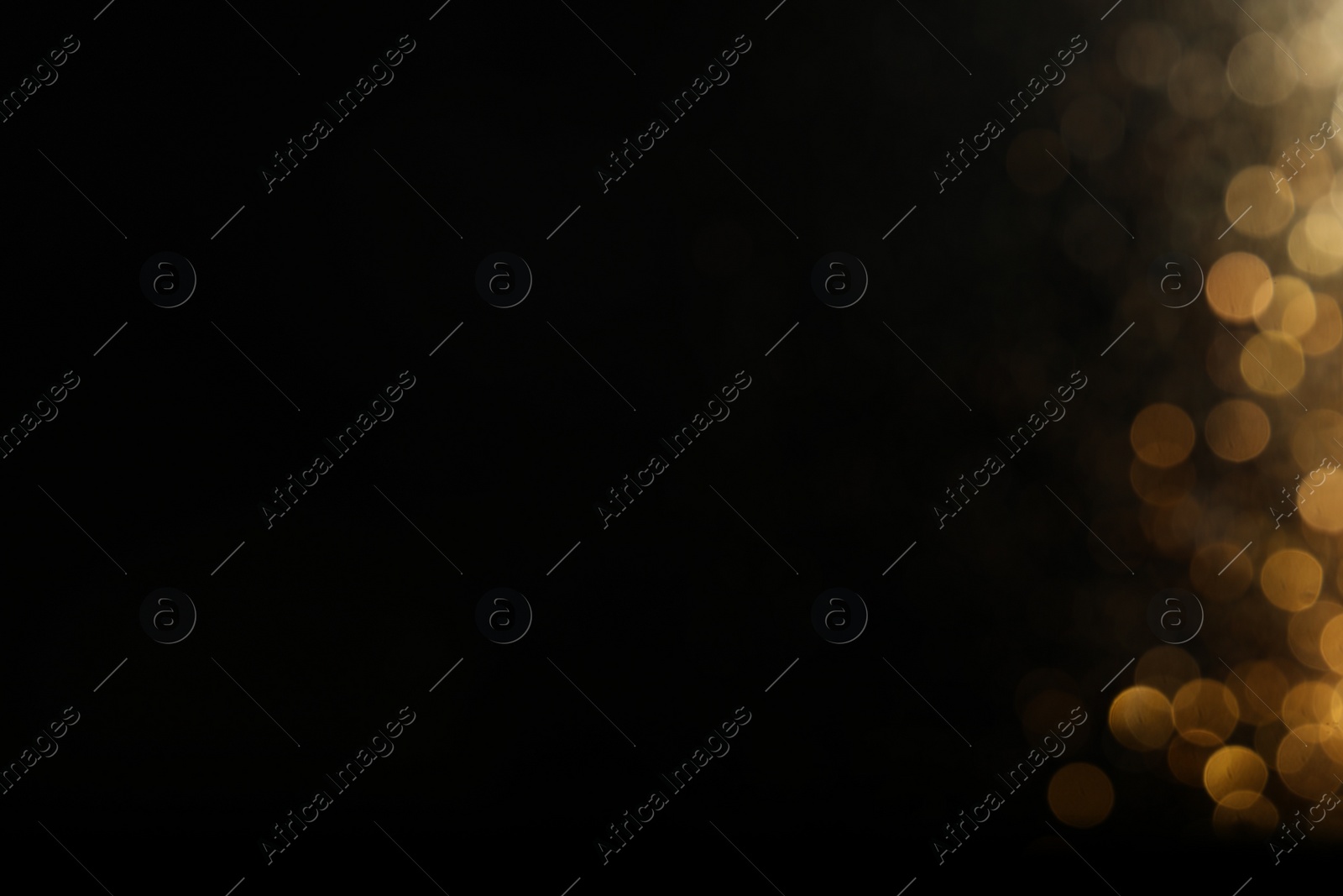 Photo of Blurred view of golden lights on black background, space for text. Bokeh effect