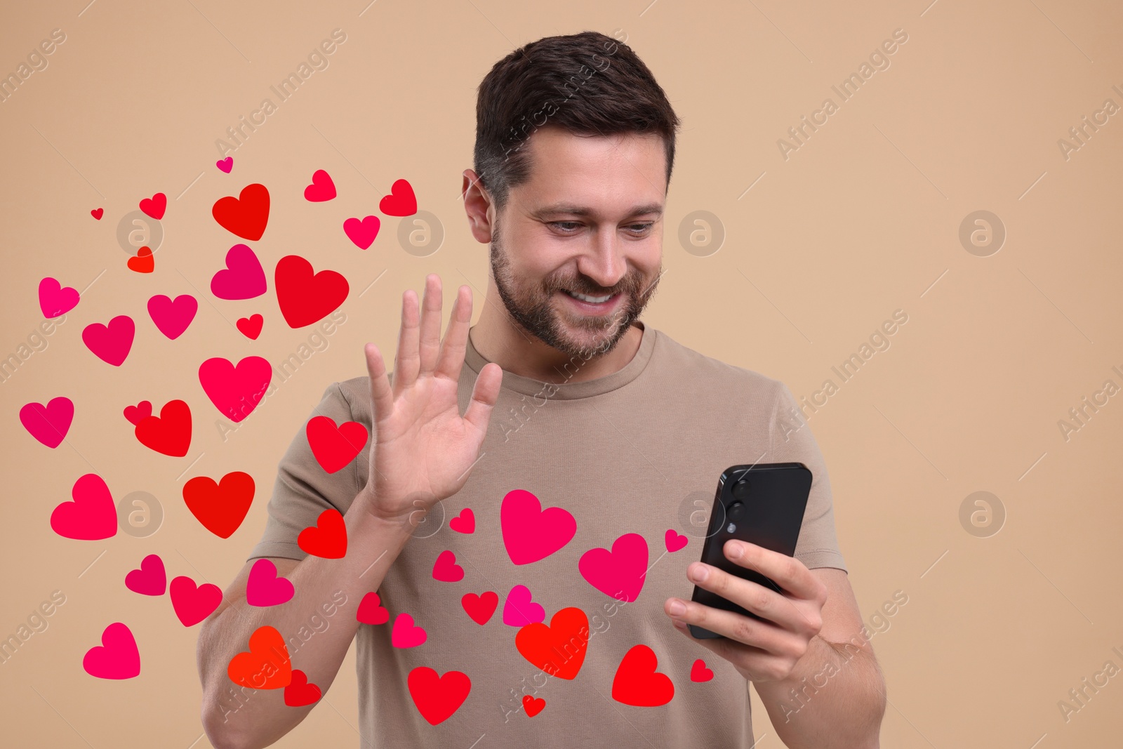 Image of Long distance love. Man video chatting with sweetheart via smartphone on grey background. Hearts flying out of device