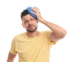 Unhappy man using cold pack to cure headache on white background