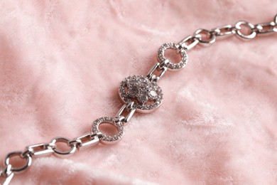 Photo of Elegant jewelry. Luxury bracelet on pink cloth, closeup