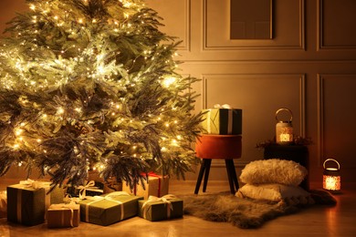 Photo of Beautiful Christmas tree decorated with festive lights and many gift boxes in room