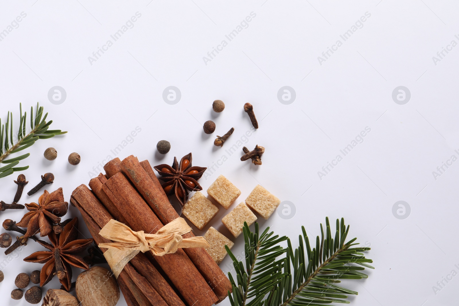 Photo of Different spices, nuts and fir branches on white table, flat lay. Space for text