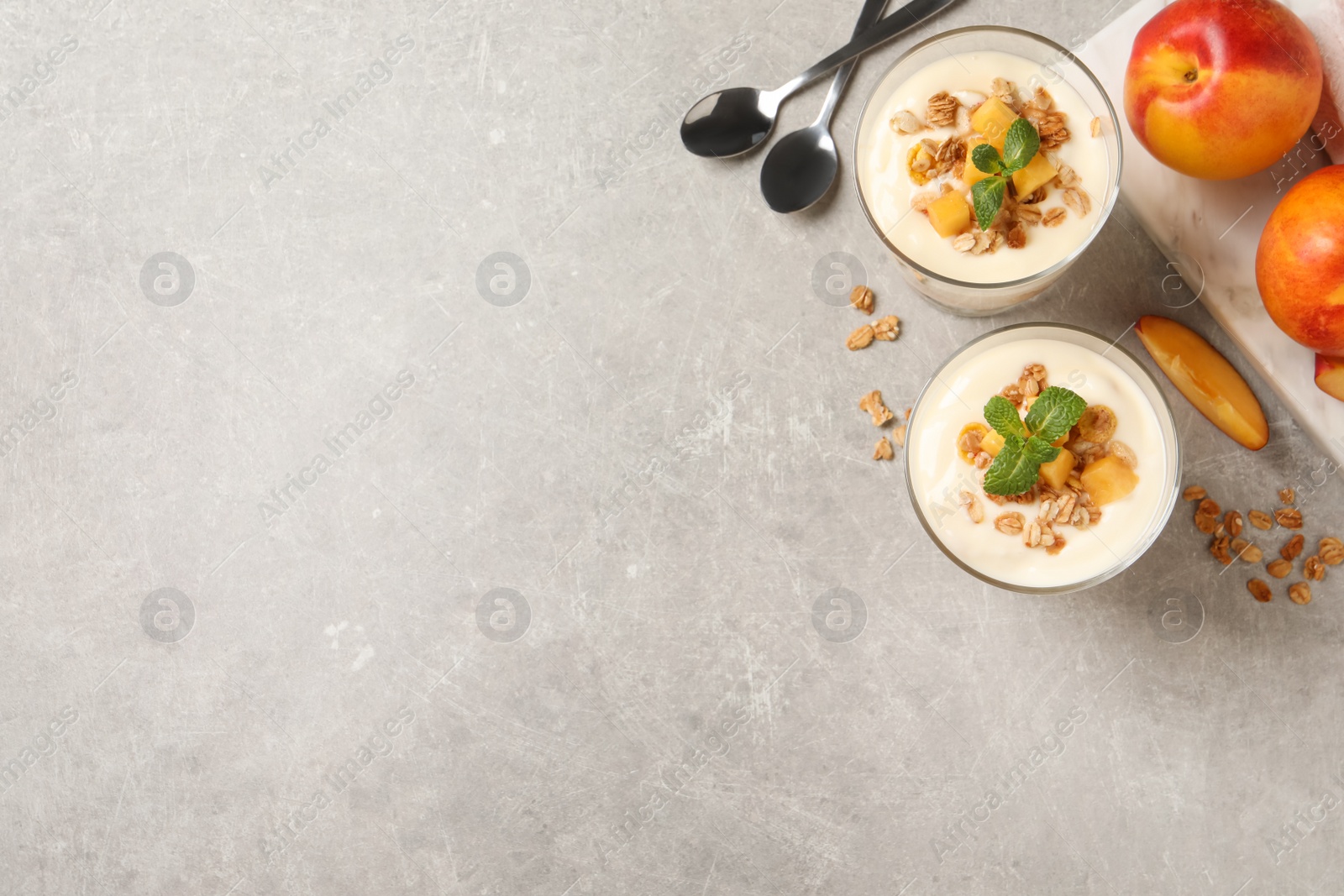 Photo of Flat lay composition with tasty peach yogurt on light grey table. Space for text