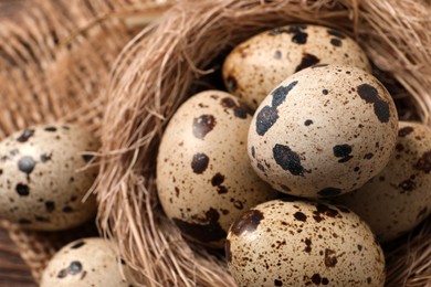 Photo of Nest with quail eggs on table, closeup