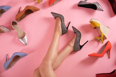 Photo of Woman and different high heel shoes on pink background, top view
