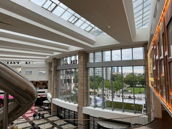 Photo of Modern shopping mall with glass ceiling, view from inside