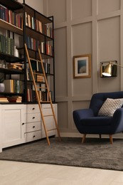 Photo of Cozy home library interior with collection of different books on shelves and comfortable place for reading