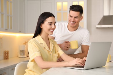 Photo of Happy couple wearing pyjamas and spending time together in kitchen