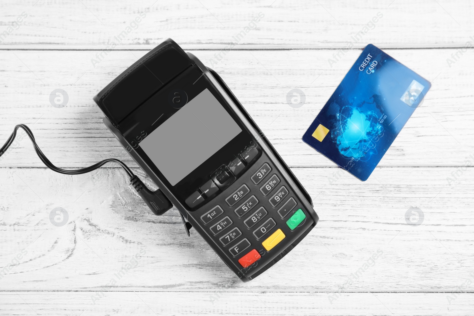 Photo of Modern payment terminal and credit card on white wooden background, top view