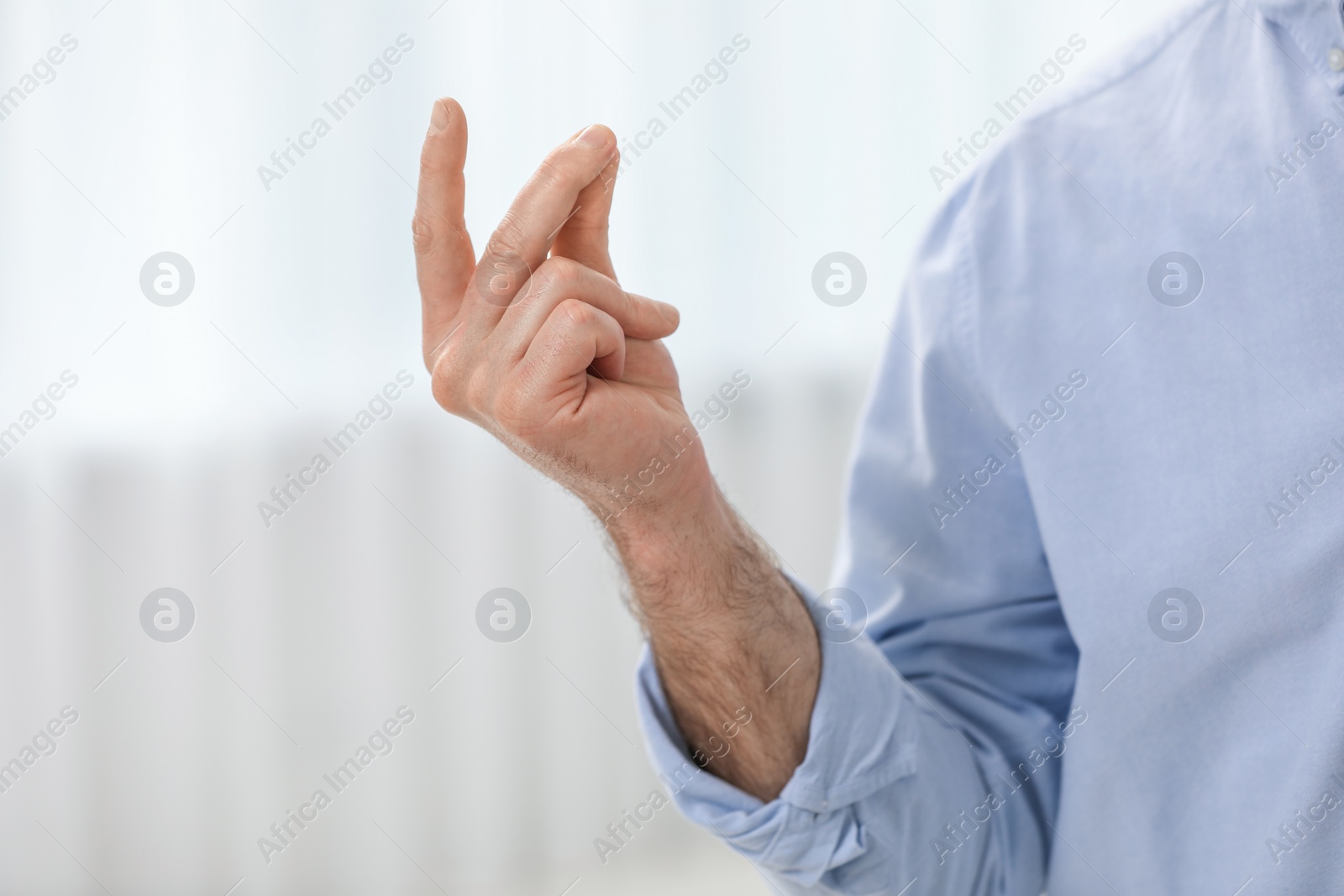 Photo of Man snapping his fingers indoors, closeup. Bad habit