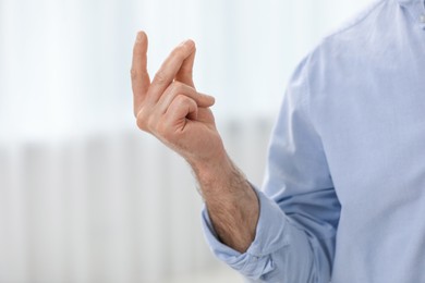 Photo of Man snapping his fingers indoors, closeup. Bad habit