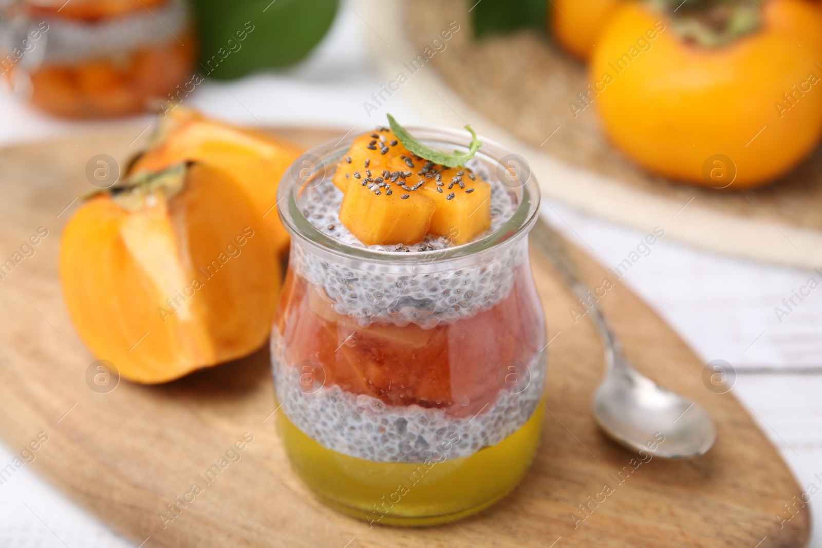 Photo of Delicious dessert with persimmon and chia seeds on table