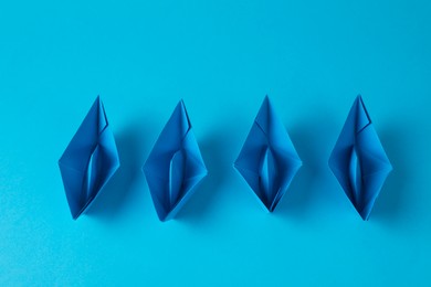 Photo of Handmade paper boats on light blue background, flat lay. Origami art