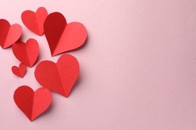 Paper hearts on pink background, flat lay. Space for text