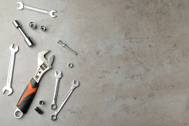 Photo of Auto mechanic's tools on grey background, flat lay. Space for text