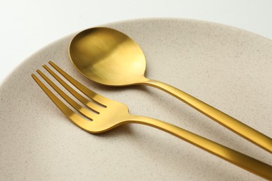 Photo of Clean plate, fork and spoon on white table, closeup