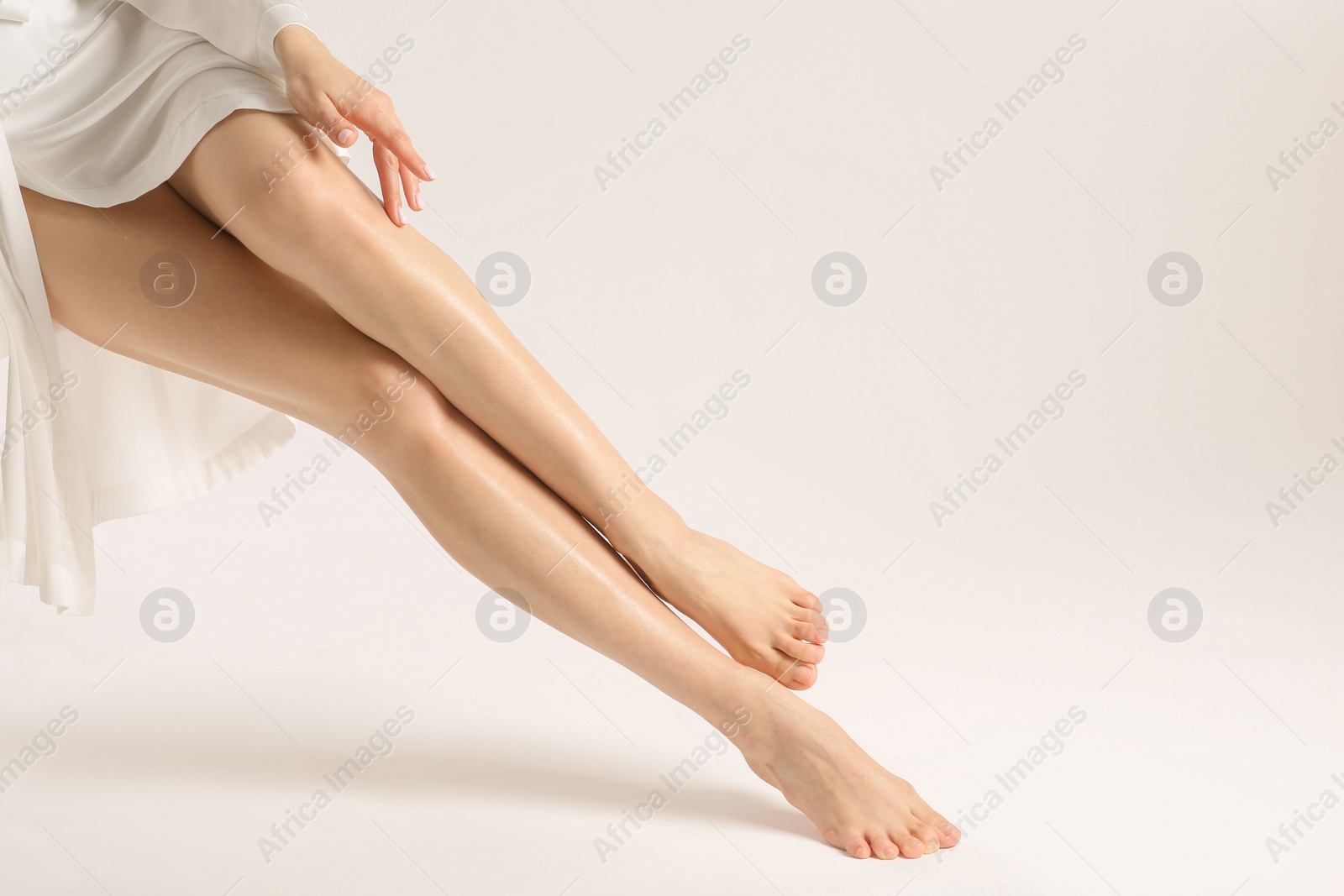 Photo of Woman with beautiful smooth legs on white background, closeup. Space for text