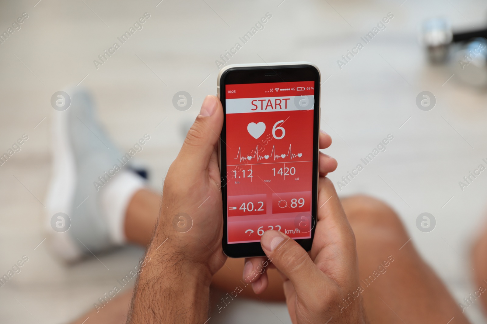 Photo of Man using fitness app on smartphone indoors, closeup