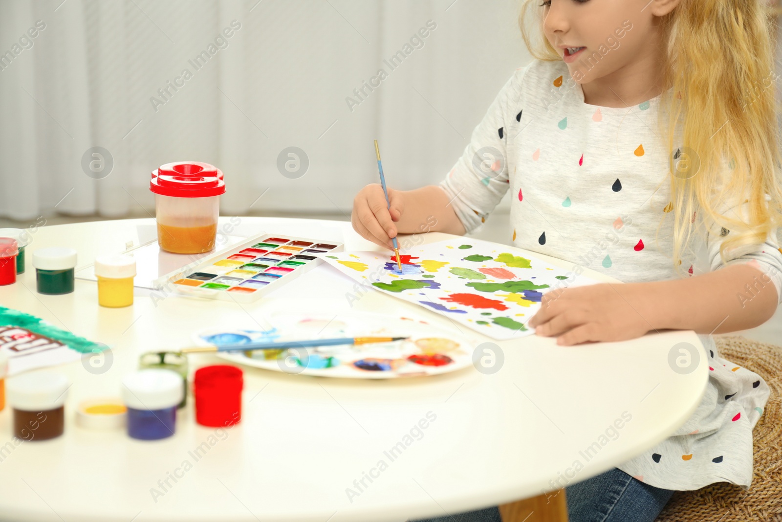 Photo of Little child painting at light table, closeup