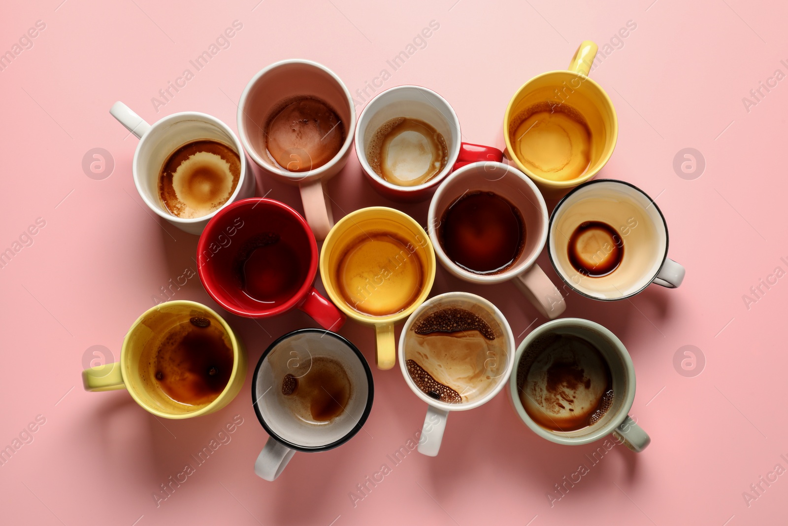 Photo of Many dirty cups after drinking coffee on pink table, flat lay