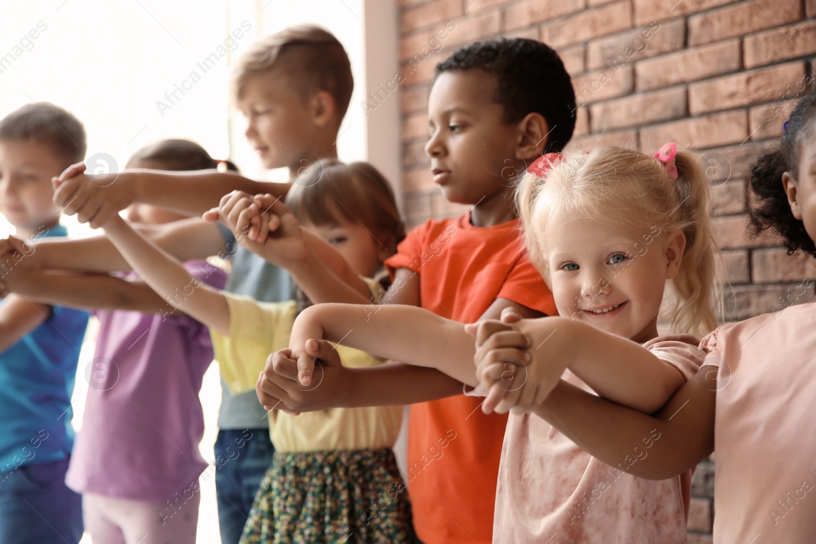 Photo of Little children holding hands together indoors. Unity concept