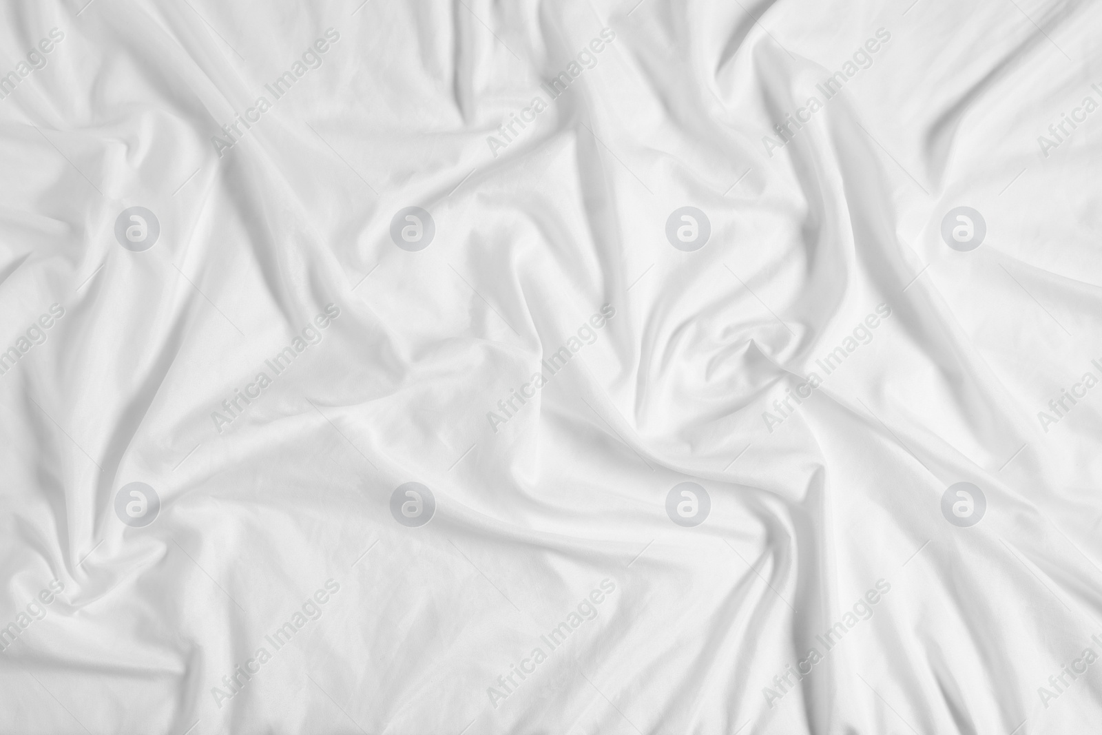 Photo of Crumpled white fabric as background, top view