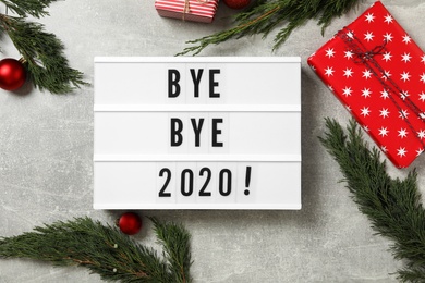 Photo of Lightbox with text Bye Bye 2020! and festive decor on grey background, flat lay