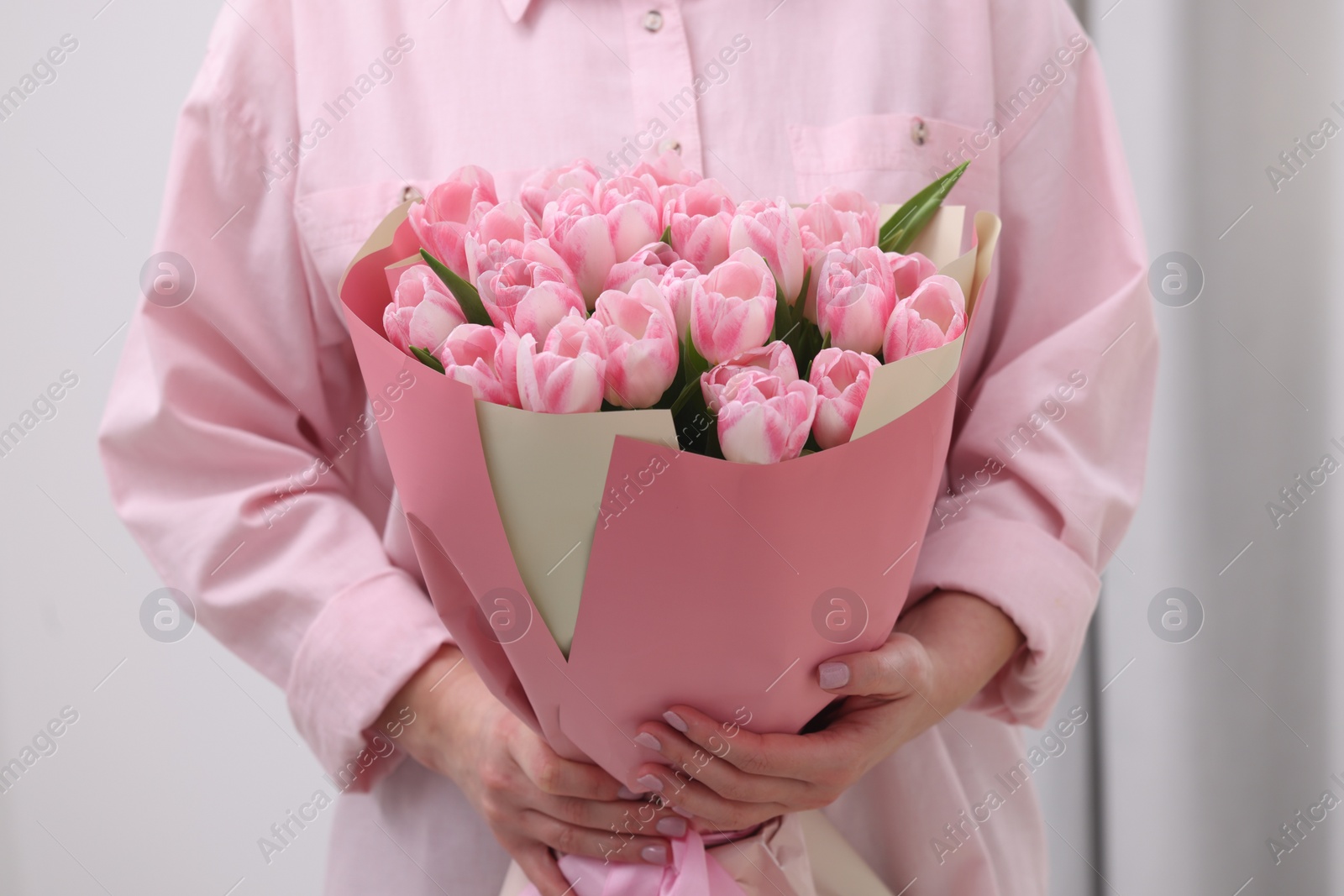 Photo of Woman with bouquet of beautiful fresh tulips on blurred background, closeup