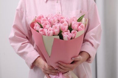 Woman with bouquet of beautiful fresh tulips on blurred background, closeup