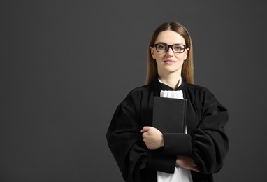 Portrait of judge with book on grey background. Space for text