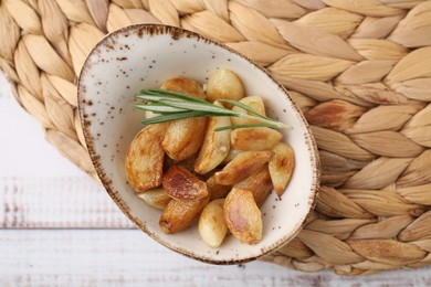 Photo of Fried garlic cloves and rosemary on table, top view