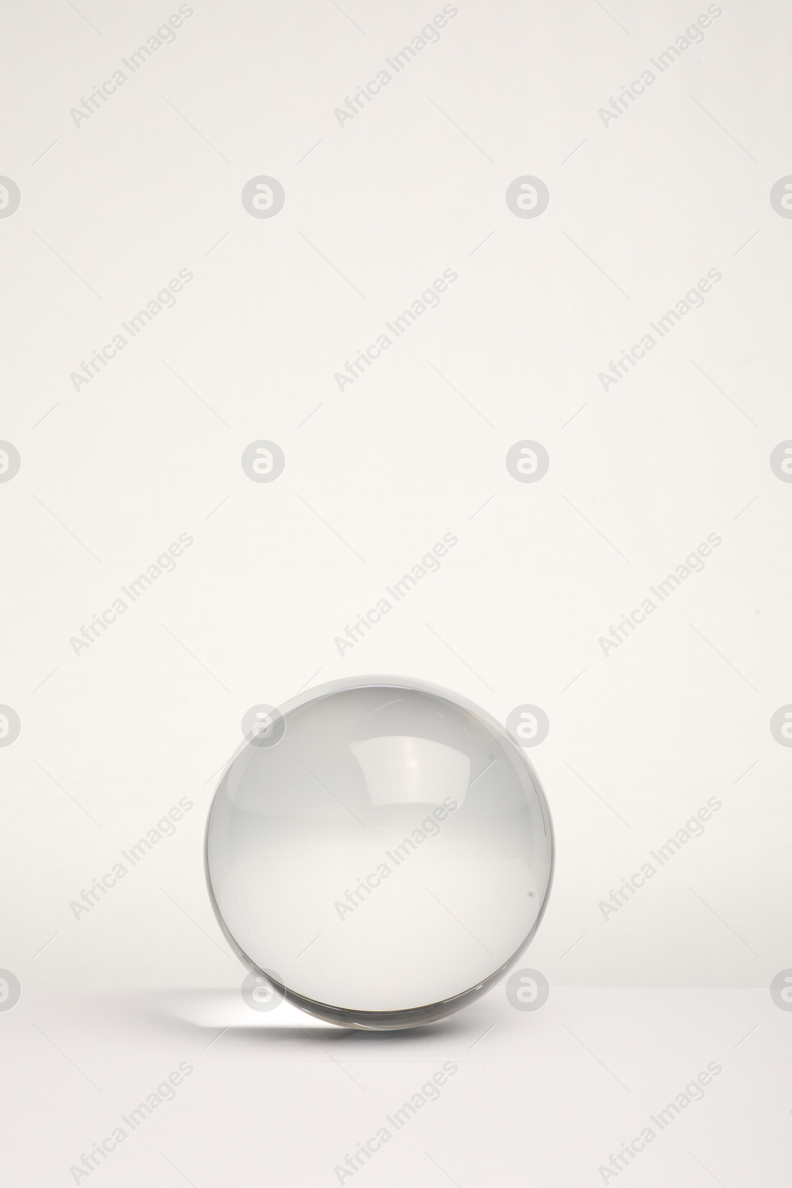 Photo of Transparent glass ball on white background. Space for text