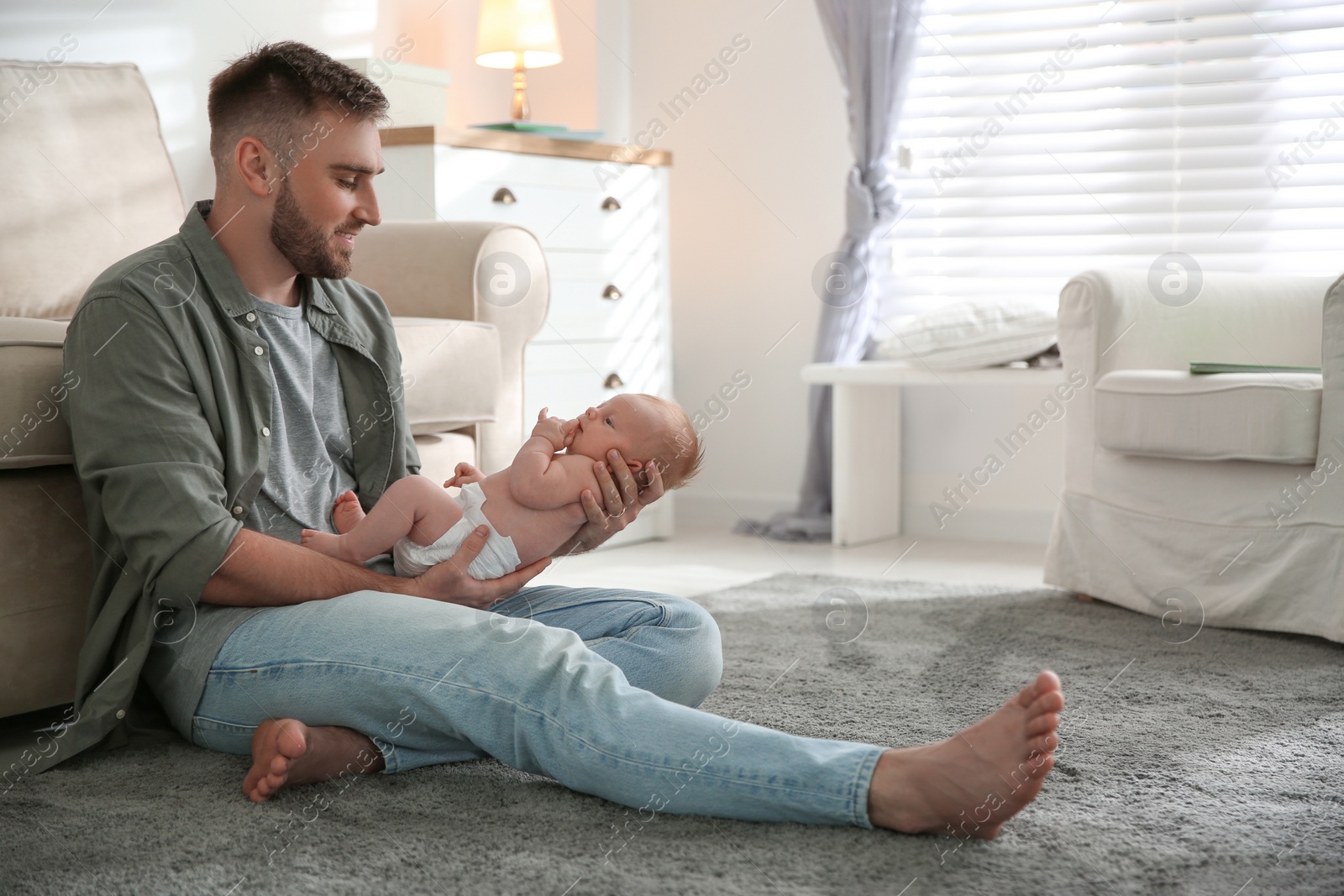 Photo of Father with his newborn son at home